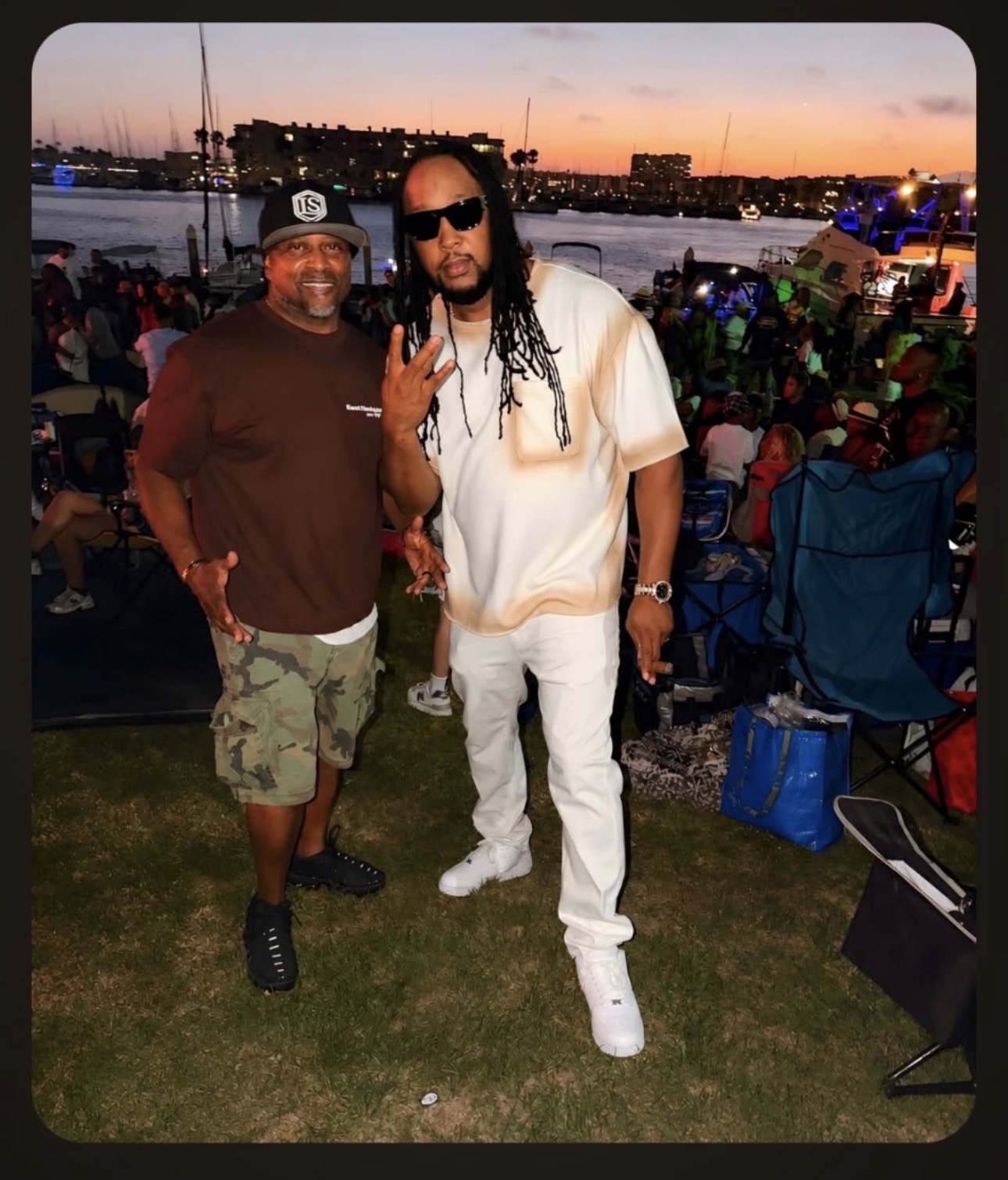 Lamont Hewitt with a recording artist at a waterfront concert at sunset
